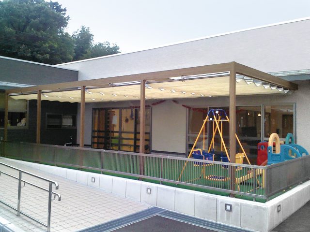 教育施設の日よけにフレーム・ポーチ壁付タイプとロープ式開閉シェードを使用